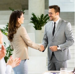 Signature d'un accord entre un homme en costume et une femme, représentant une collaboration pour creer une societé en Tunisie en 2025