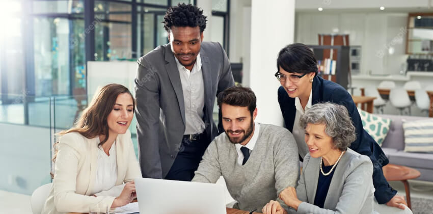 Un groupe de professionnels collaborant autour d'un ordinateur dans un espace de travail moderne, illustrant le processus de réservation de nom de société auprès du RNE.