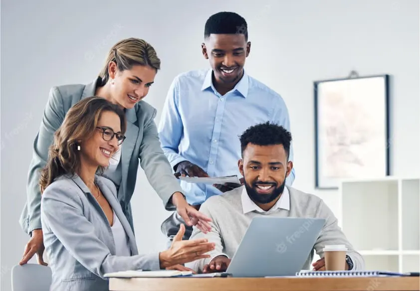 Quatre conseillers juridiques du bureau d'affaires Legal Crea, souriants et attentifs, discutent d'un accompagnement juridique autour d'un ordinateur portable.