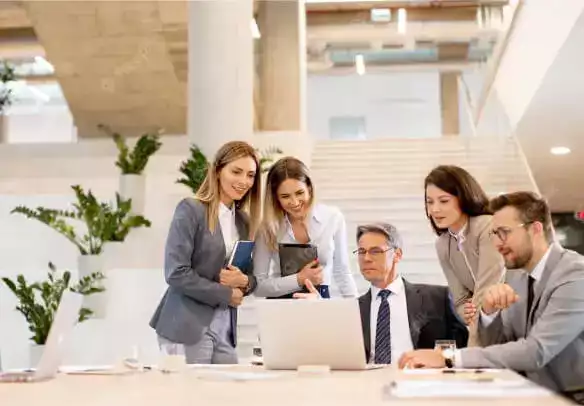 Des entrepreneurs discutent autour d’un ordinateur portable pour créer une société de services.